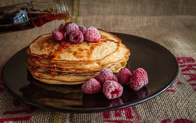 Pancakes topped with berries and syrup, a simple Valentine’s Day dessert at home.